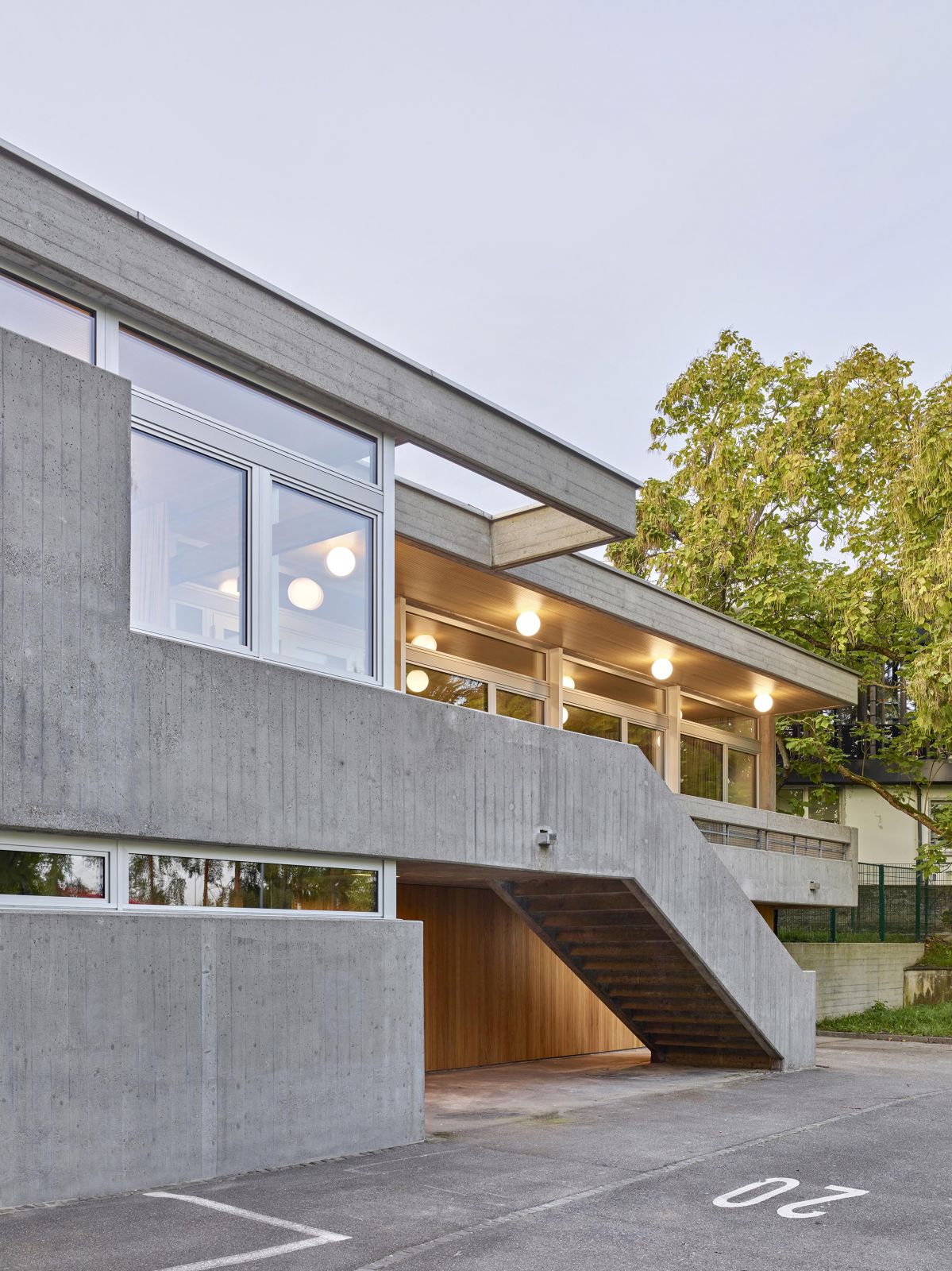 Das Gebäude ist in eine Geländekante im südlichen Teil der Anlage eingebettet und fungiert als Scharnier zwischen Stadtraum und der ruhigen Parkanlage. 7_Verkehrsgarten_Nordfassade_Licht_Lukas_Raeber_Architekten_%C2%A9Weisswert_3